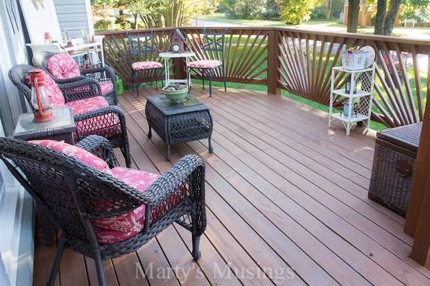 Deck furniture with cushions on stained front deck