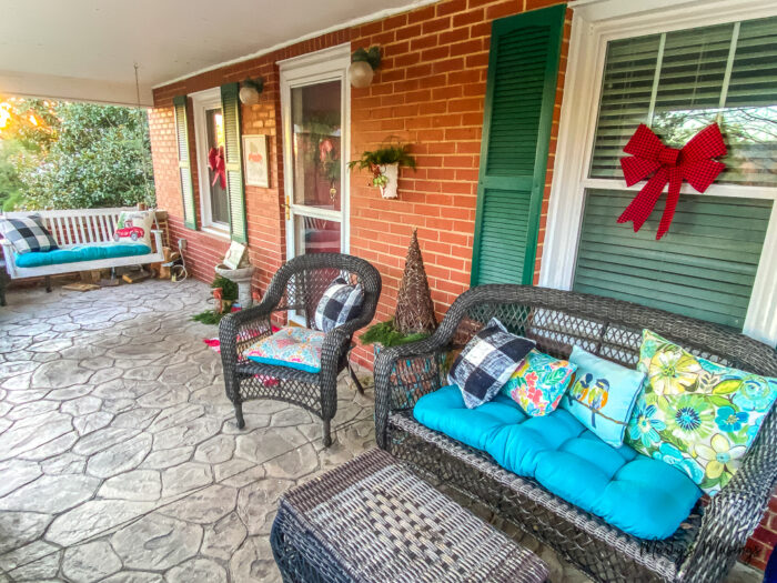 Craftsman style front porch decorated for Christmas with reds and greens