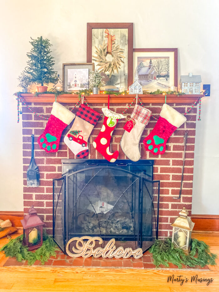 Red brick fireplace with Christmas stockings and mantle with churches