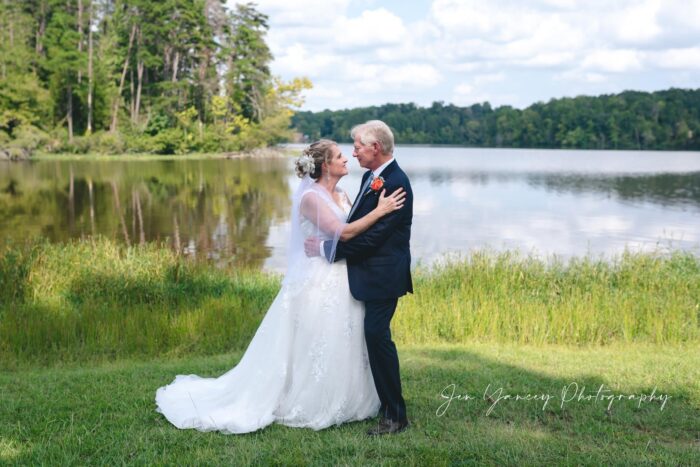 Older couple in wedding attire in front of lake